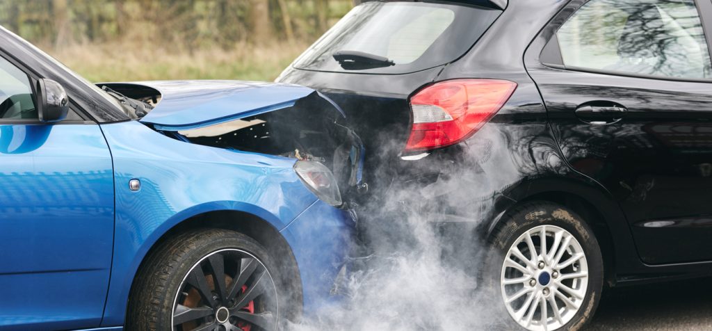 Two Damaged Cars Involved In Road Traffic Accident Showing Smoke After Collision