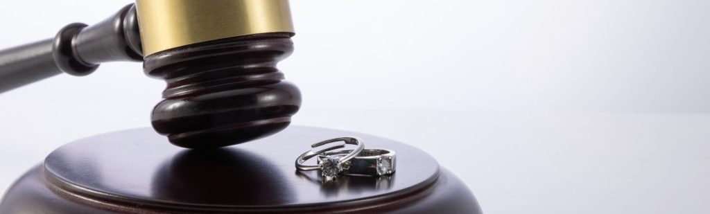 Closeup Shot Of The Judge's Gavel With Wedding Rings Concept Of Divorce